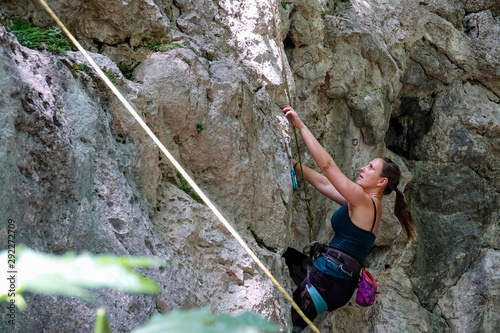 CLOSE UP: Focused woman looks for a crease in the wall while rock climbing