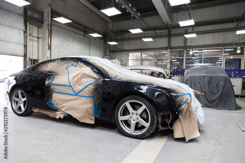 Schilderij op canvas The car after the accident in the camera for body repair is partially covered wi