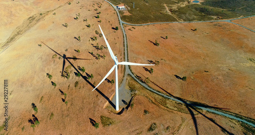Wind park with wind turbines under the blue sky. Renewable energy production for the green environmental world - aerial view with a drone - environment & ecological concept