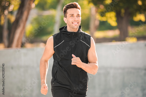 Sporty young man running outdoors