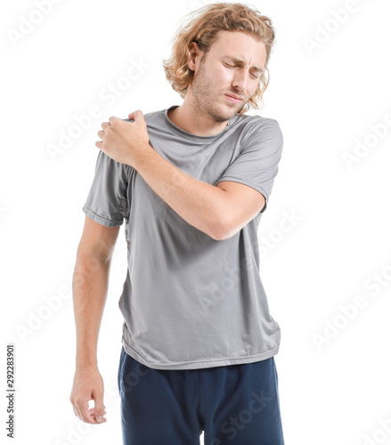 Young man suffering from pain in shoulder on white background