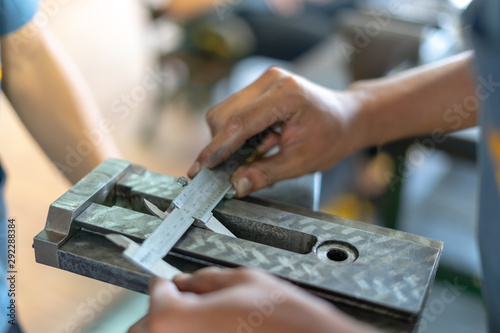 Man's hands using Vernier caliper to measure the object