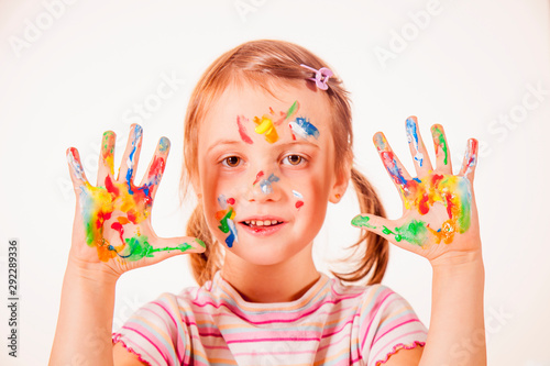 Happy little girl with colorful painted hands and face.