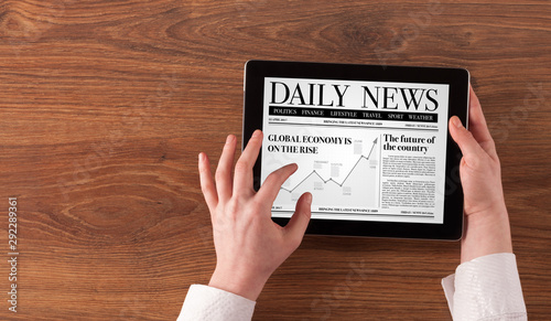 Hand with tablet reading news on tablet