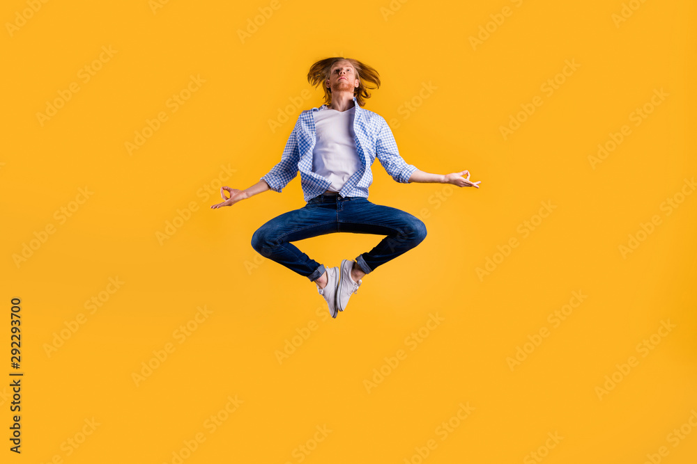 Full size photo of redhead guy jumping high meditating exercise holding body in lotus position wear casual trendy outfit isolated yellow background