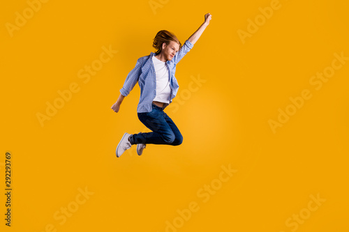 Full size photo of crazy redhead guy jumping high using super power to fly faster and save world wear casual trendy outfit isolated yellow background © deagreez