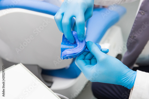 Foto Dentist prepares material for a mold of teeth