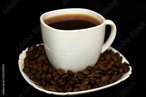 cup of coffee with coffee beans on black background