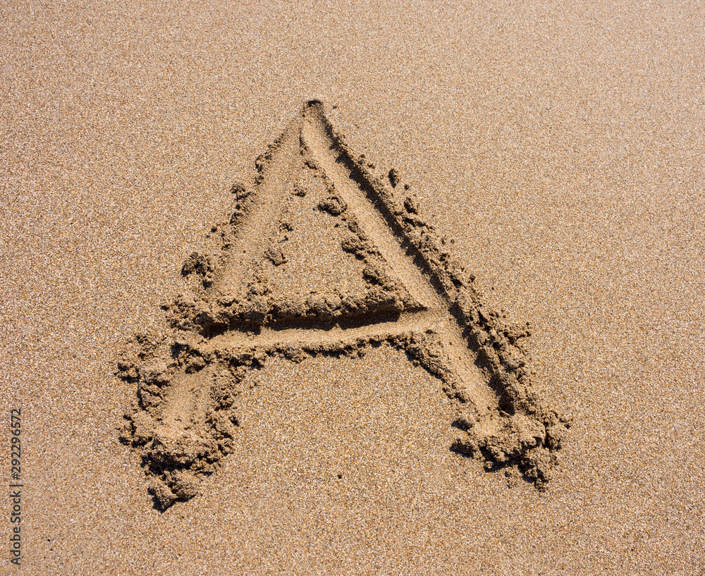 Alphabet's letter A handwritten in sand on the beach Stock Photo