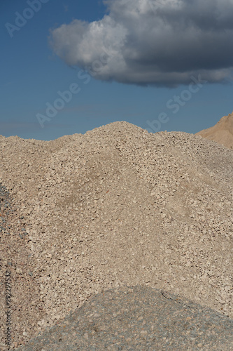 Mountains of sand and stone against a blue sky