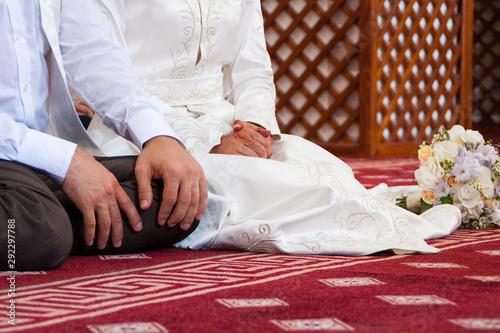 Muslim wedding rite. Bride and groom sitting on the floor in the moqsue. Muslim Wedding prayers. Nikah
