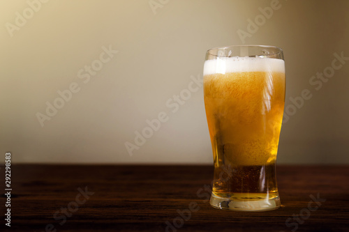 Glass of Beer on Wooden Table. Front View. Shot with Natural Daylight photo