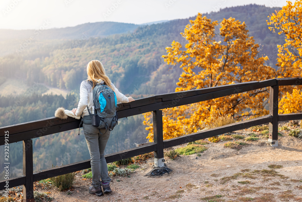 Woman hiker enjoying view to mountain at autumn season