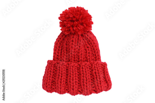 Small red knitted bobble hat isolated on a white background. Handmade woolly hat with pompom. Closeup. Copy space