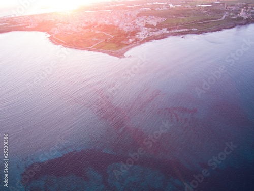 Wonderful aerial view at sunset of the coastline of Portopalo, a town in the southern Sicily. The shot is taken during a beautiful sunny day at sunset photo
