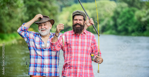 Fisherman with fishing rod. Bearded men catching fish. Mature man with friend fishing. Summer vacation. Happy cheerful people. Family time. Activity and hobby. Fishing freshwater lake pond river