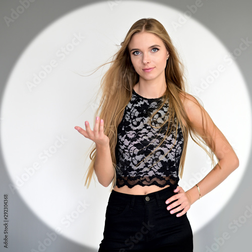 Concept for advertising photo, banner, portrait of a pretty blonde girl with long hair. Standing right in front of the camera, smiling. Style, fashion, glamor, beauty.