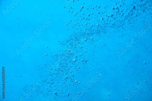 Photography of emerging bubbles in blue water