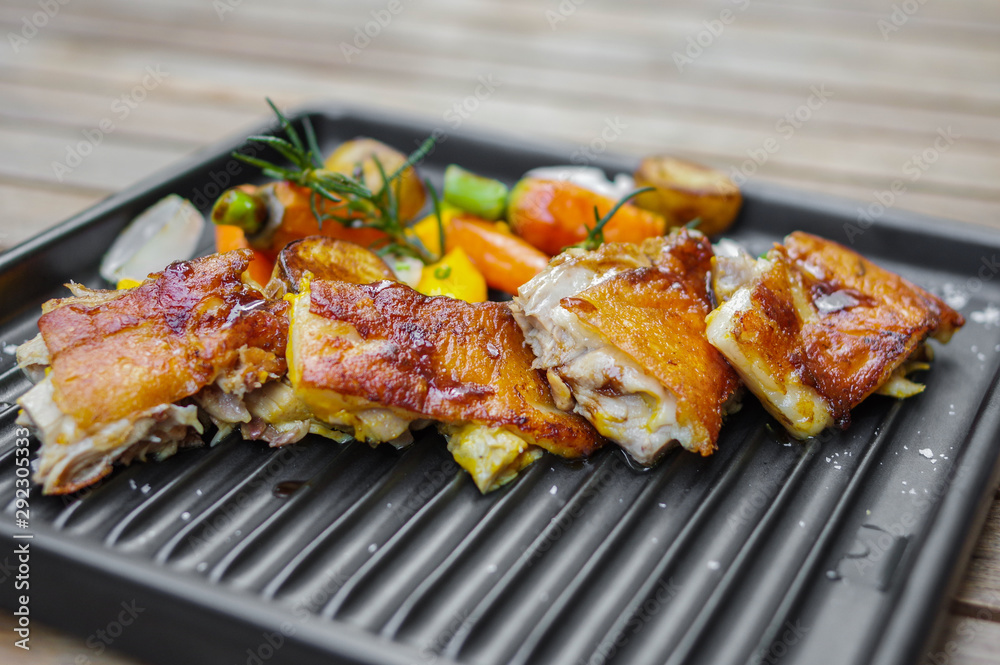 Roasted chicken meat slices with baby carrots, garlic, small potatoes, rosemary, sea salt and mango sauce on black nonstick oven tray