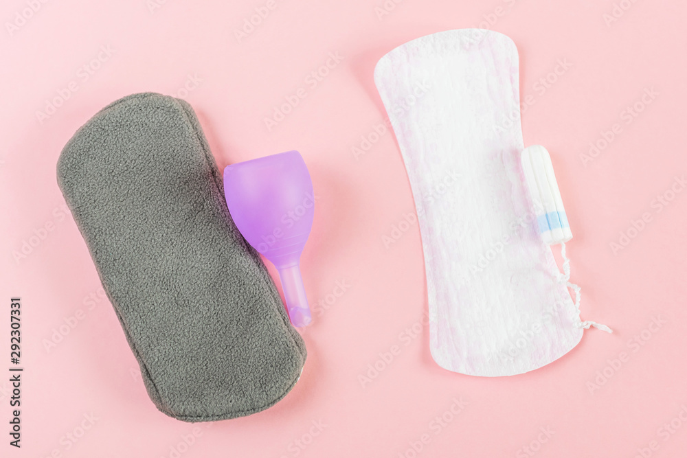 Reusable eco-friendly female pad, menstrual cup, tampon and usual women's pad. Pink background, place for text, minimalism, top view, flat lay. Zero waste concept Reusable eco-friendly female pad, menstrual cup, tampon and usual women's pad. Pink background, place for text, minimalism, top view, flat lay. Zero waste concept