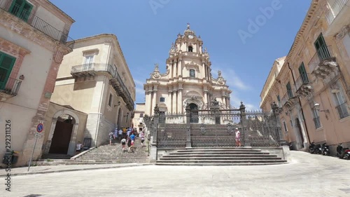 Some tourists visiting the baroque cathedral in the historic center of Ragusa Ibla in Sicily, Italy.