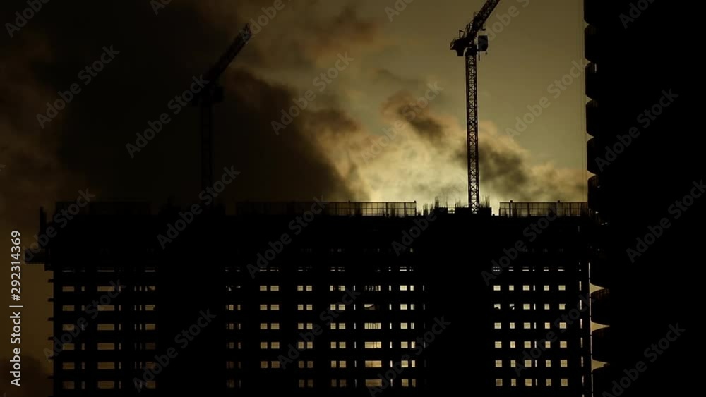 Construction work with a tower crane while sunset. Time laps.