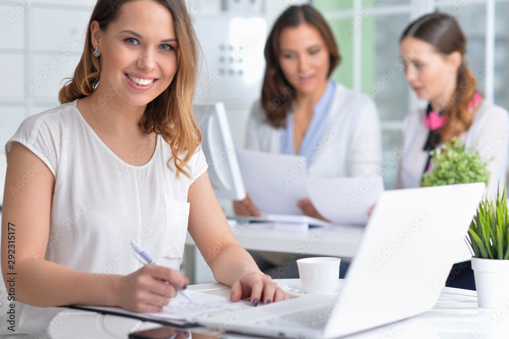 young women sit at the table and work in a modern office young women sit at the table and work in a modern office