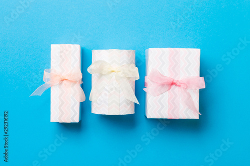 Gift box with Colored bow for Christmas or New Year day on blue background, top view
