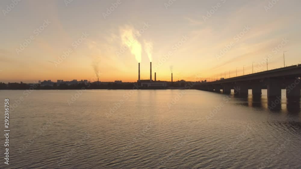 Air pollution, ecology. 4k aerial smoking plant at golden sunset. River. Air pollution, ecology. 4k aerial smoking plant at golden sunset. River.