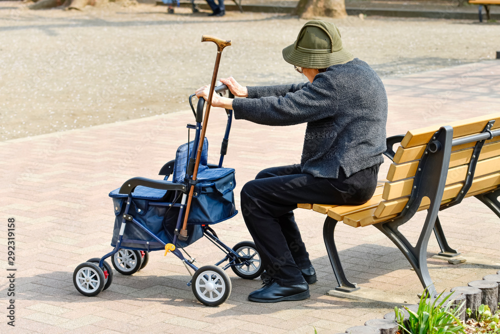 Obraz premium ベンチに座る高齢者の女性