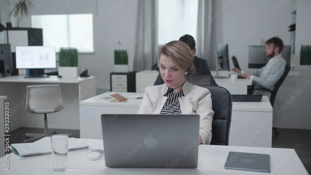 Woman and her collegues sit at a table and work. Woman and her collegues sit at a table and work.