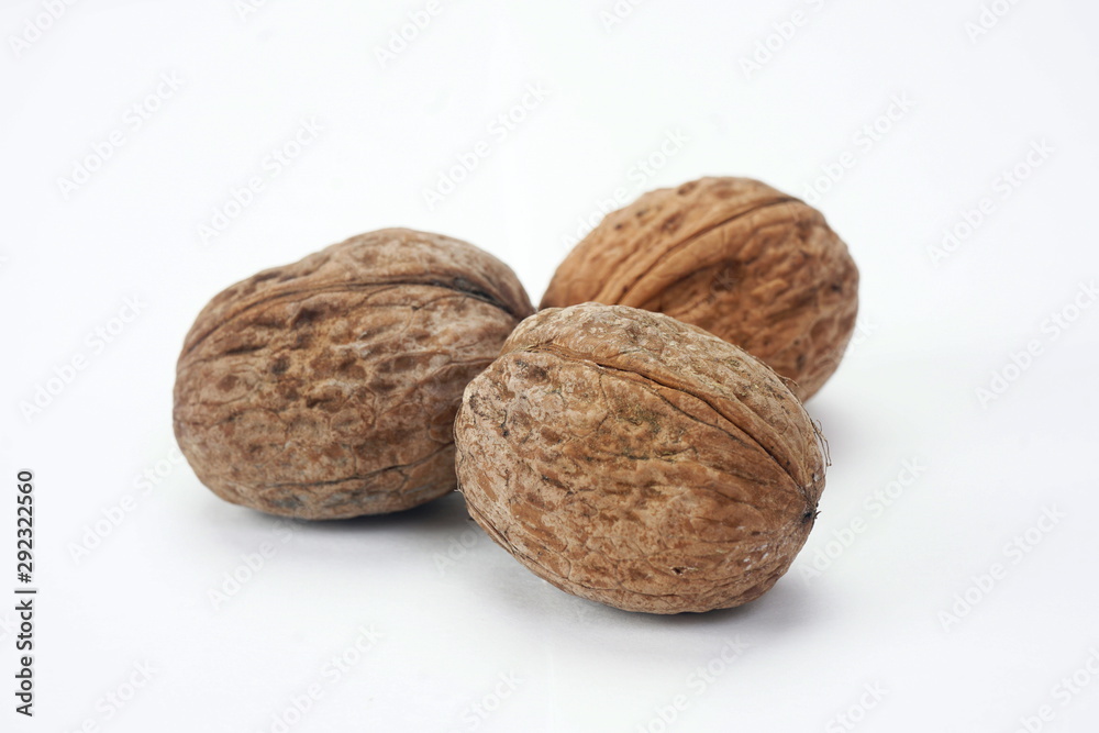 Ripe dry walnuts isolated on a light background. Concept natural, healthy food Ripe dry walnuts isolated on a light background. Concept natural, healthy food
