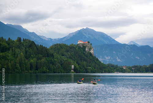 Beautiful landscape of Lake Bled with background of Bled castle on the hill and tourist kayaking in the lake.