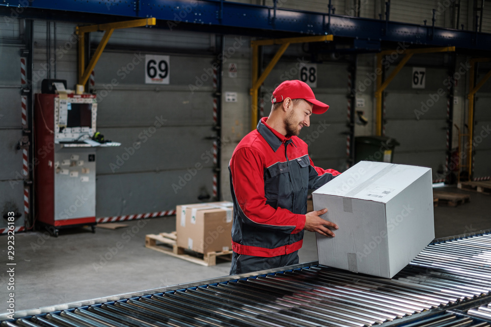 Warehouse worker working on a conveyor line Warehouse worker working on a conveyor line