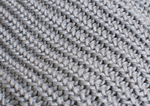 Gray knitted texture for background. Soft warm knitted scarf. Knitting concept.