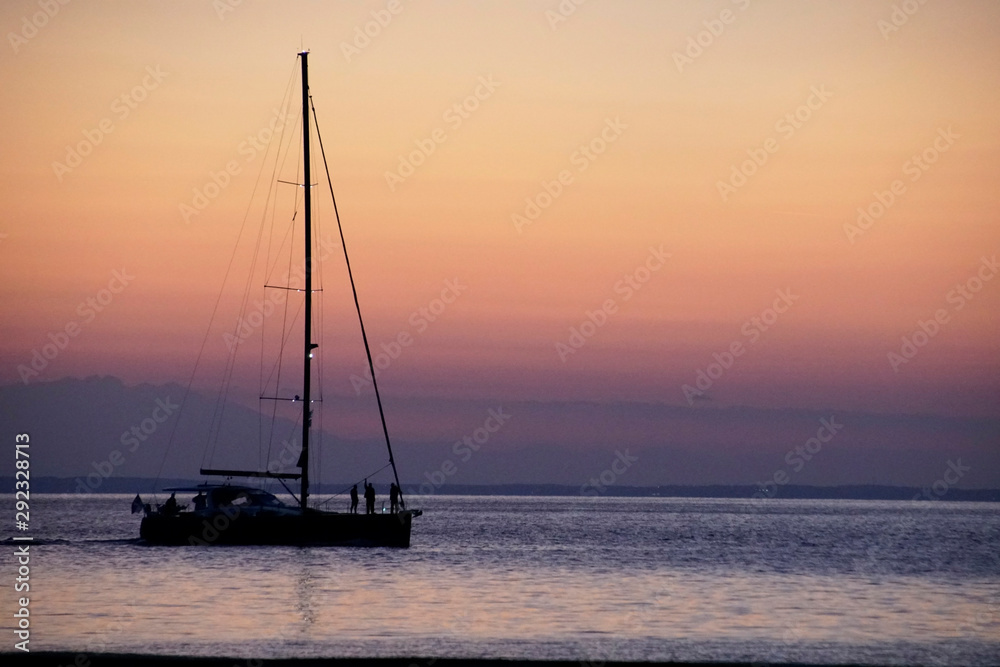 Silhouette of a yacht against the background of a sunset. 