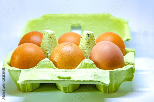 Half a dozen eggs in a paper egg box.