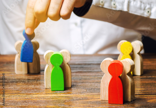 Groups of multicolored wooden people and businessman. The concept of market segmentation. Target audience, customer care. Market group of buyers. Customer relationship management. Selective focus photo