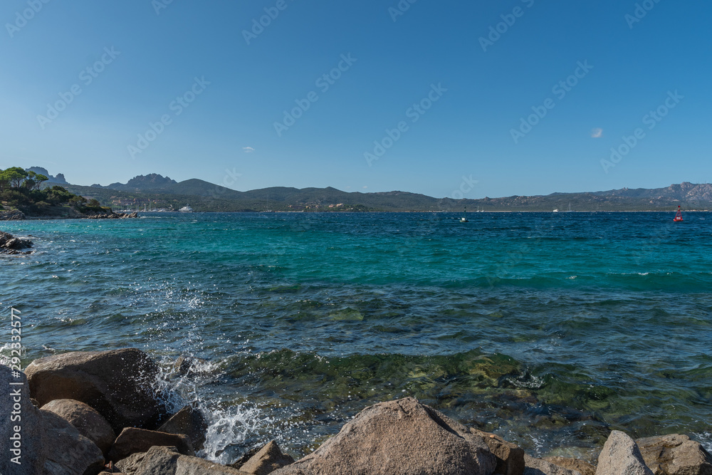 View from the rocky shore of the sea and mountains on a clear day