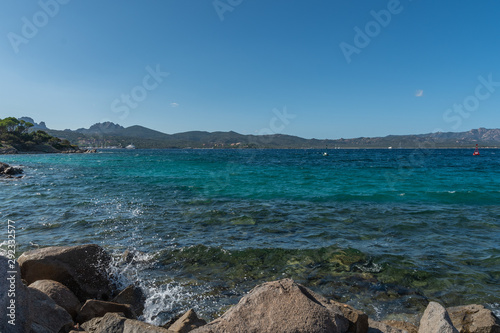 View from the rocky shore of the sea and mountains on a clear day