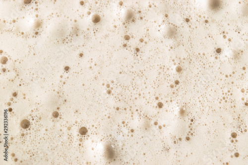 Macro shot Beer foam bubbles  texture background. Craft beer flowing foam with sparkling bubbles. Beer foam texture close up.