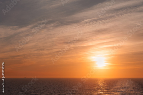 Sunset and colorful sky on the sea with a wake left by a cruise ship © Gianluca