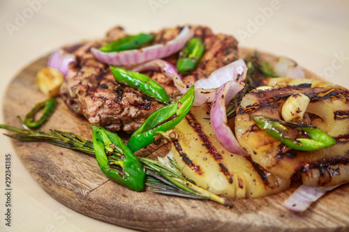 Grilled pork with pineapple, red onion and hot green pepper. Serve on a wooden board.