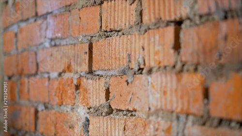 The process of priming a brick wall. A primer solution is applied to a brick wall using a roller thus and so to remove dust and increase adhesion. Processing of brickwork by priming. T