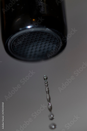Drops of water flowing from faucet