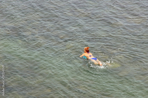 Mature woman swims in the sea monitors the health of sea baths