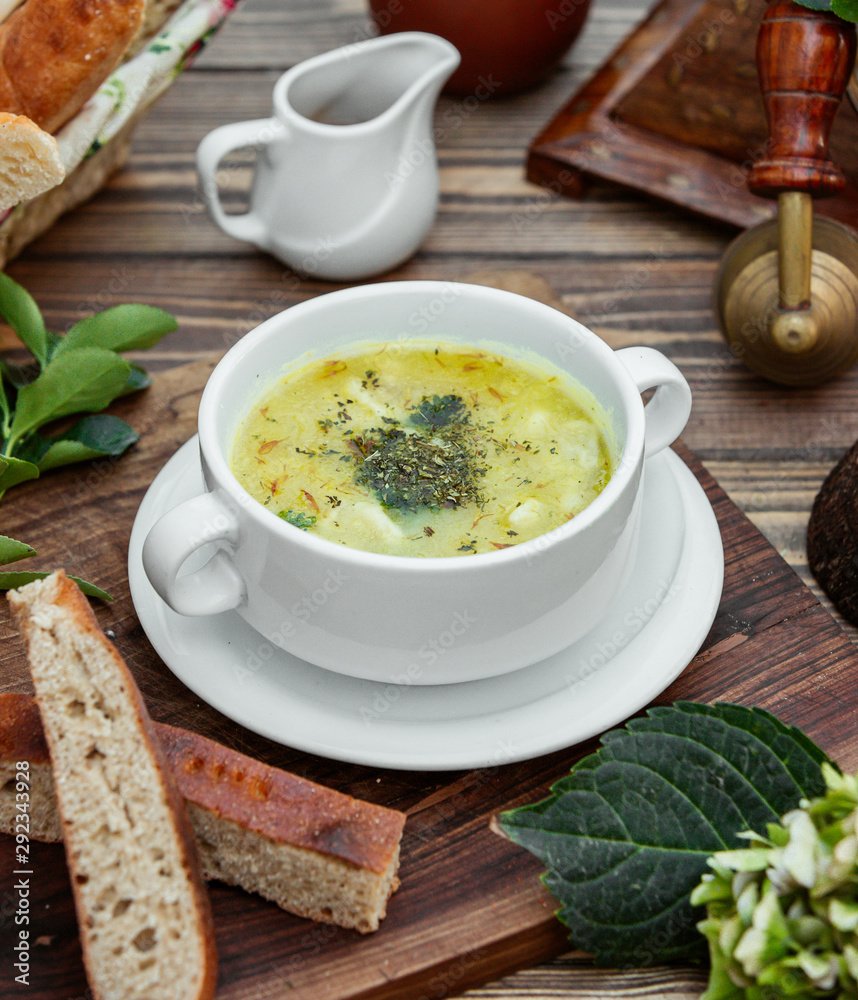 Dushbara dumpling soup served with bread on wooden table Dushbara dumpling soup served with bread on wooden table
