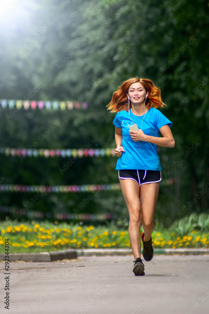 Obraz premium young asian woman with Red hair jogging in a city park