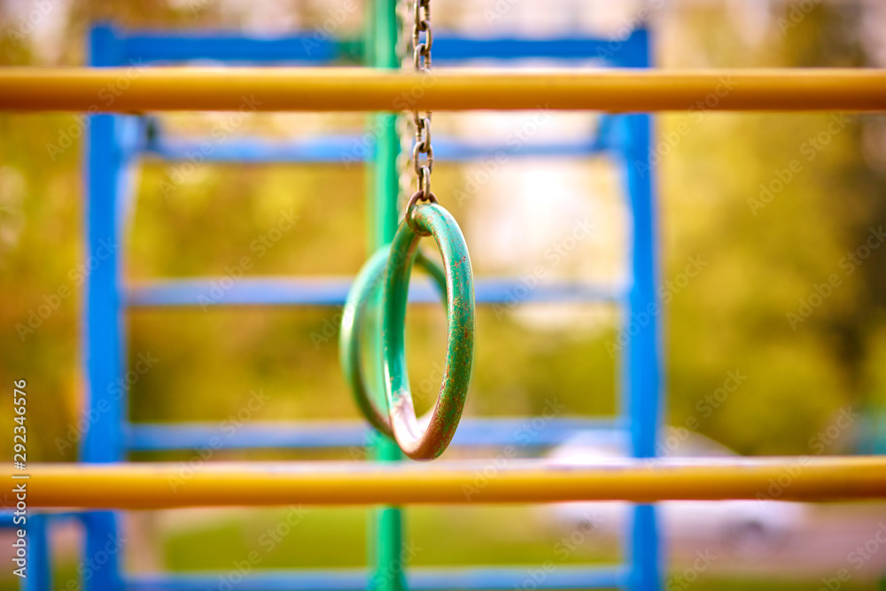 Horizontal bar, iron rings on the chain. Summer texture Horizontal bar, iron rings on the chain. Summer texture