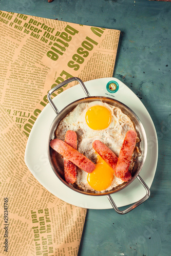 Fototapeta Naklejka Na Ścianę i Meble -  Sunny up side eggs for breakfast with half cutted and fried sausages